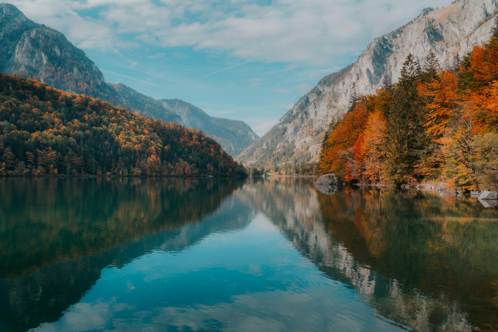 Peaceful autumn lake with colorful foliage reflecting mountains in Eisenerz, Austria.
