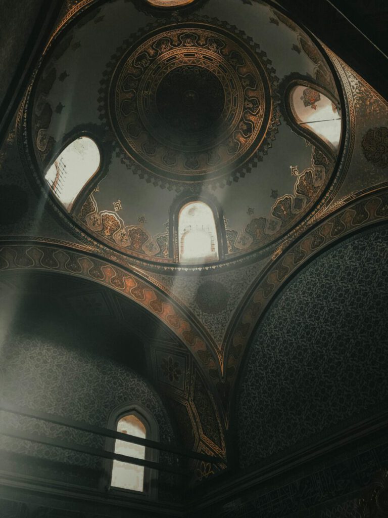 From below dome inside of ancient Topkapi Palace located in Istanbul decorated with arches and golden ornaments
